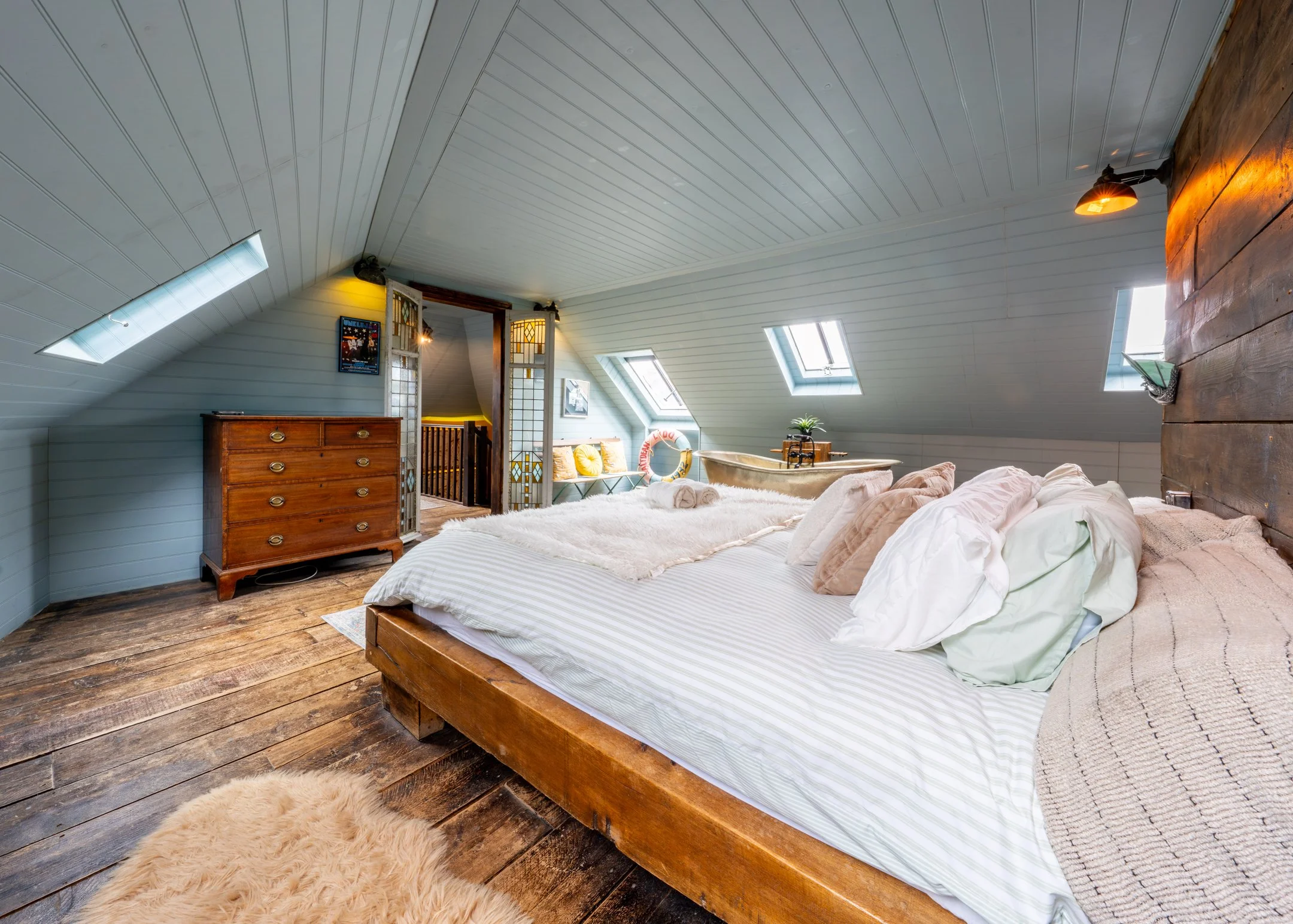 Master bedroom with sloped ceiling and king bed